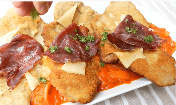 Filetes empanados de terneras de Vuelta y Vuelta, también llamado Milanesa, con lascas de queso por encima y jamón serrano.