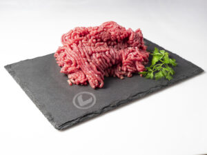 Carne Picada de ternera Vuelta y Vuelta sobre una pizarra y con una ramita de perejil