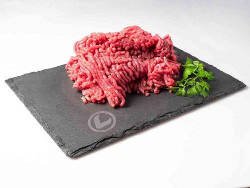 Carne Picada de ternera Vuelta y Vuelta sobre una pizarra y con una ramita de perejil