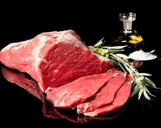 Filetes de ternera cortados de una pieza de cadera. Aparece también aceite de oliva virgen una rama de olivo