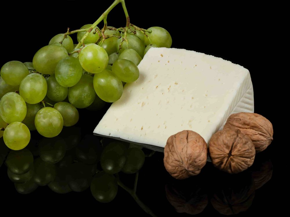 Cuña de queso manchego tierno, con nueces y uvas verdes