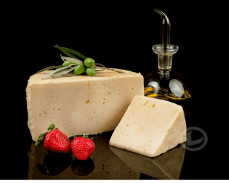 Queso en aceite la Mozalba, medio queso, una cuña y una aceitera con AOVE. También una rama de olivo y unas fresas