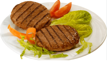 hamburguesas vegetales en un plato en el que hay también lechuga y tomate