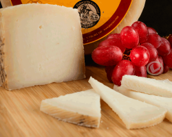 queso payoyo semicurado de cabra, una cuña en primer plano y unas cuantas lonchas.