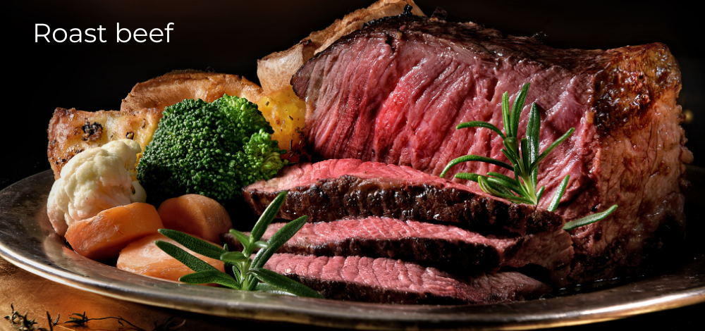 Roast beef asado en bandeja de metal cortado y con verduras