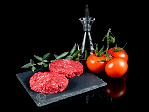 Hamburguesas de ternera Vuelta y Vuelta, con tomate natural y aceite de oliva en una botella bonita y una rama de olivo