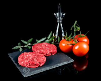 Hamburguesas de ternera Vuelta y Vuelta, con tomate natural y aceite de oliva en una botella bonita y una rama de olivo