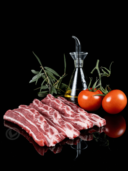 Tiras de churrasco de terneras de Vuelta y Vuelta. Aparece aceite de oliva virgen extra y tomates.